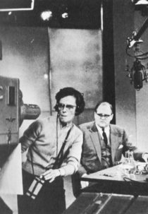 Dimbleby behind a desk, Joan Marsden checking a camera position