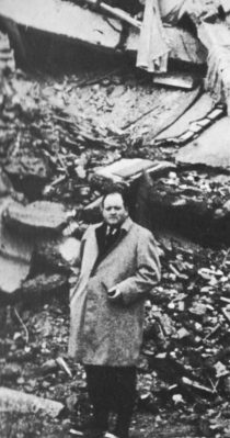 Dimbleby stands in rubble