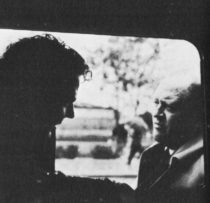 Two men framed by the window of a car or train
