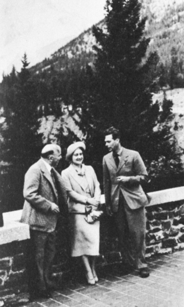 Three people lean on a wall