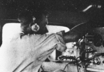 A man in. headphones operates radio equipment