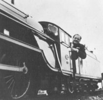 Dimbleby in a tiny steam locomotive